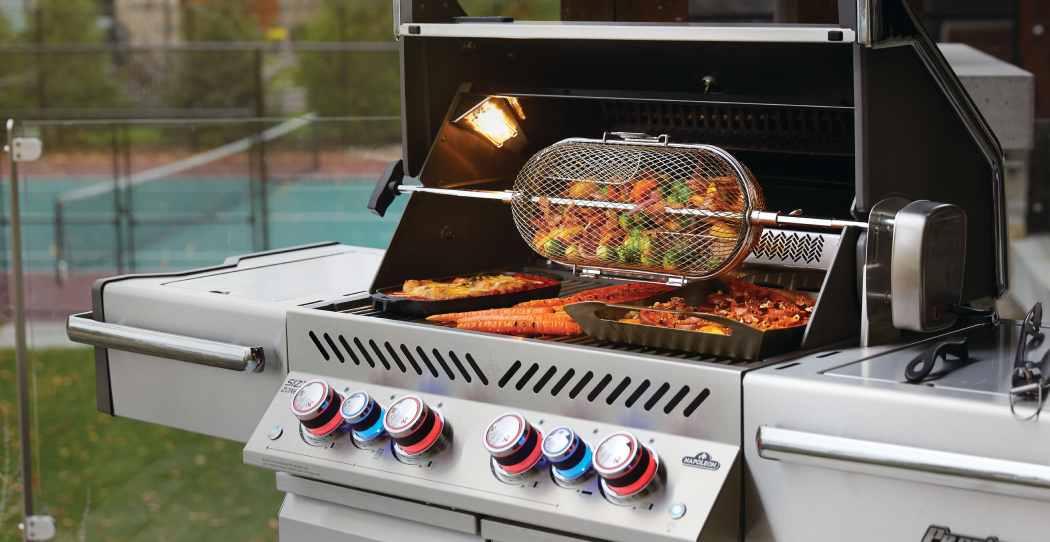 Stainless steel grill full of cooked meats and vegetables